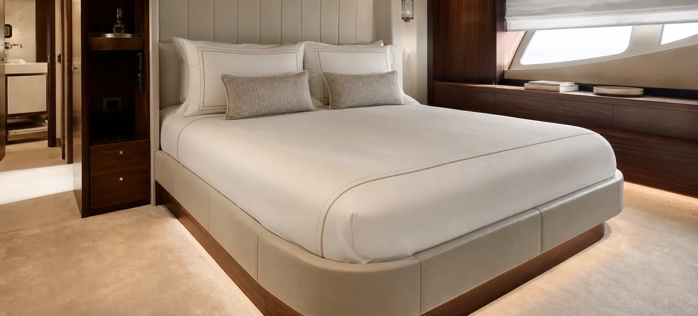 Yacht cabin prepared with fitted white bed linen.